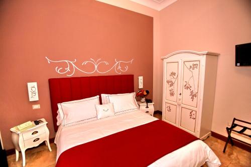 a bedroom with a large bed with a red headboard at B&B Milu' in Crotone