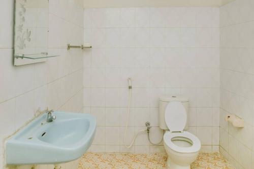 een badkamer met een toilet en een wastafel bij Nakula Familiar Inn in Denpasar