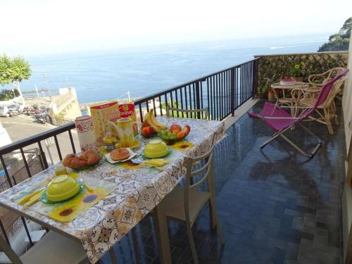 una mesa con comida en un balcón con vistas al océano en Blue Oasis, en Piano di Sorrento