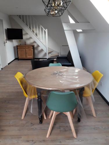 une table à manger avec des chaises et un escalier dans l'établissement appartement 1ere étage dans maison individuelle, à Saint-Jacques-sur-Darnétal