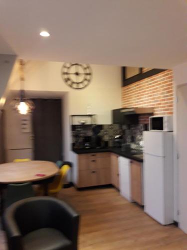 a kitchen with a table and a clock on the wall at appartement 1ere étage dans maison individuelle in Saint-Jacques-sur-Darnétal
