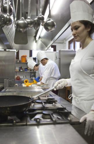 a group of chefs in a kitchen preparing food at Albergo Ristorante Belvedere in Codroipo
