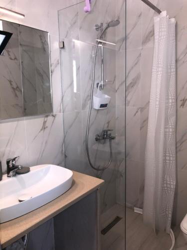 W łazience znajduje się prysznic i umywalka. w obiekcie Seaward Holiday Home w mieście Dhërmi