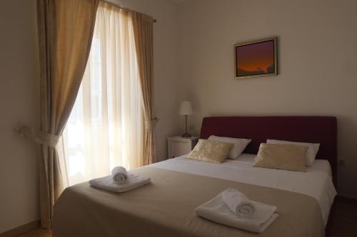 1 dormitorio con 1 cama grande y toallas. en Apartment Sv. Andrija, en Dubrovnik