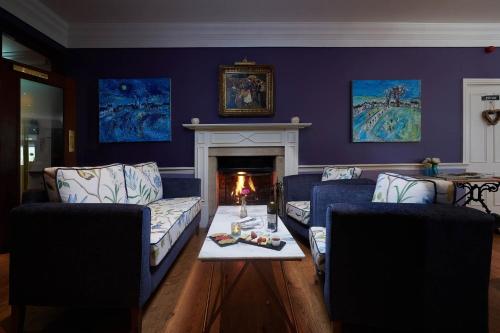 a living room filled with furniture and a fireplace at The Devonshire Fell Hotel in Burnsall