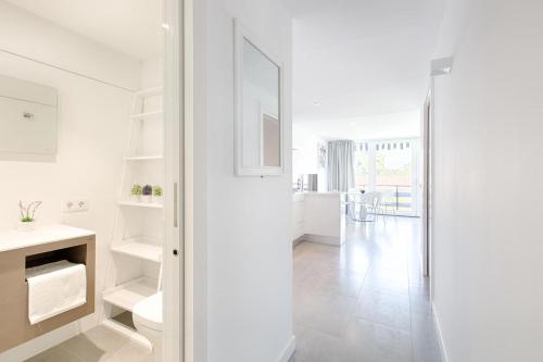 Habitación blanca con espejo y pasillo en San Pedro Apartment, en Marbella