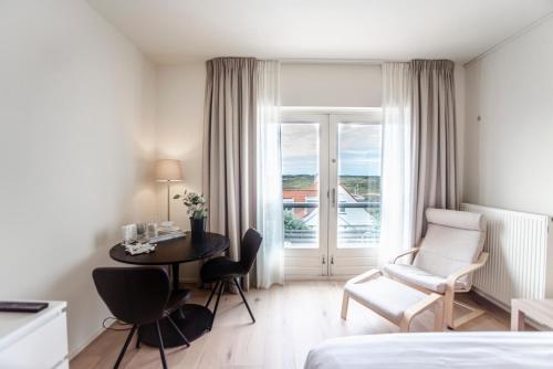 Habitación de hotel con cama, mesa y silla en Keller Beach, en Zandvoort