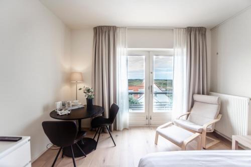 Una habitación de hotel con una cama, una mesa y una silla. en Keller Beach, en Zandvoort