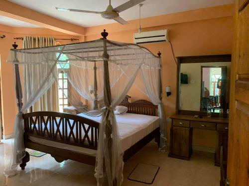 a bedroom with a canopy bed and a mirror at The Golden Residence in Kegalle