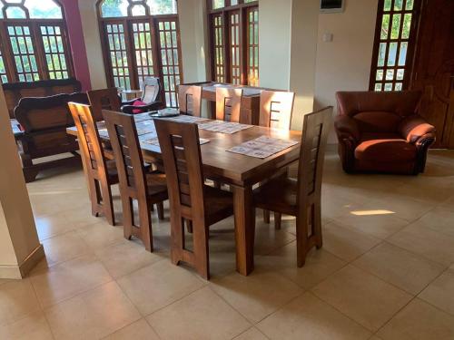 een houten tafel en stoelen in de woonkamer bij The Golden Residence in Kegalle