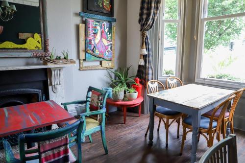 una sala da pranzo con tavolo, sedie e camino di Cavalaire Guest House a Brighton & Hove