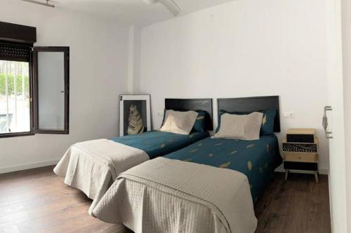 een slaapkamer met twee bedden en een raam bij Mas del Cel - Casa Rural in Confrides