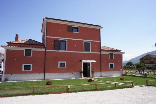 a large red building with a fence in front of it at Taverna Ferrigno in Padula