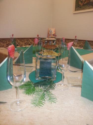 a table with four wine glasses on a table at Penzion Pod Boubínem in Kubova Huť