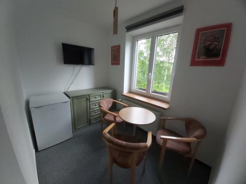 une petite cuisine avec une table et des chaises ainsi qu'une fenêtre dans l'établissement Svatý Jakub, à Janské Lázně