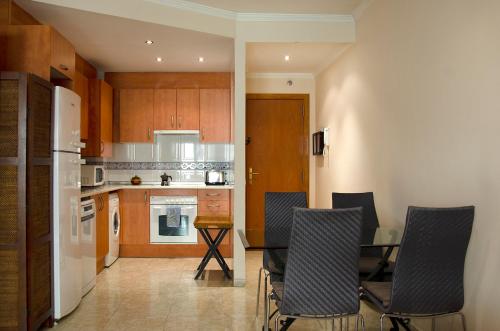 a kitchen with a table and chairs in a room at Rosa Street Apartment in Girona