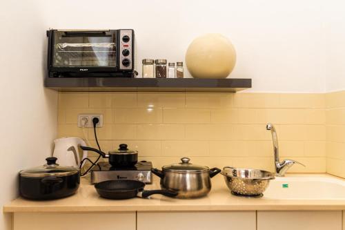 a kitchen counter with pots and pans and a microwave at סטודיו 10 studio in Eilat