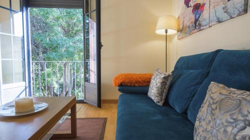 a living room with a blue couch and a table at Sefarad_Parking Propio in Toledo