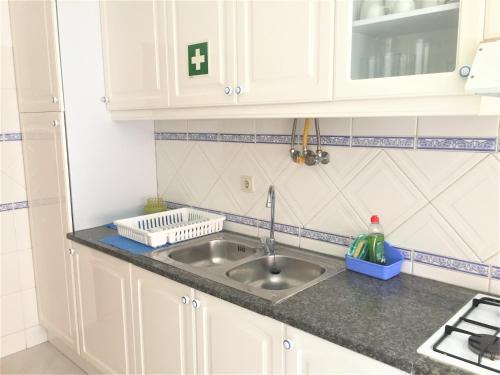 a kitchen with a sink and a counter top at Apartamento Familiar Lisboa Taguspark in São Marcos