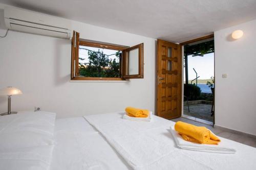 a white room with a bed with yellow objects on it at Villa Cerjan - Sevid in Sevid
