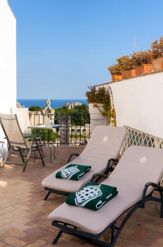 two lounge chairs on a patio with a view of the ocean at Sina Flora in Capri