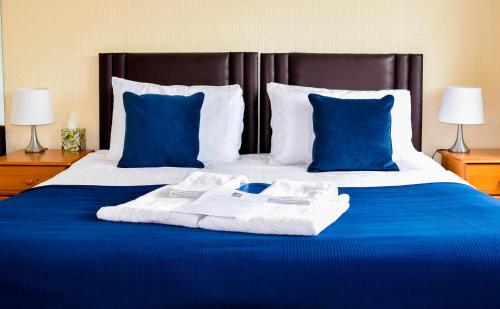 a large bed with blue sheets and blue pillows at Braemar in Shanklin