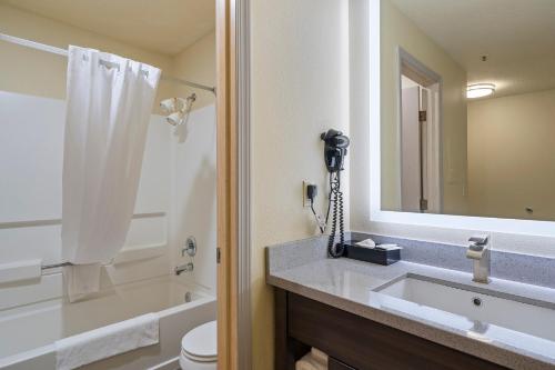 a bathroom with a sink and a toilet and a mirror at Oceanview Inn at the Arch in Long Beach