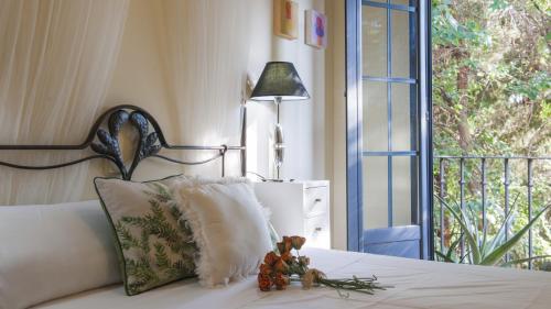 a bed with a pillow and a lamp and a window at Sefarad_Parking Propio in Toledo