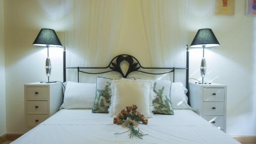 a bedroom with a white bed with two lamps at Sefarad_Parking Propio in Toledo