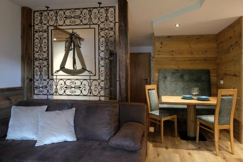 a living room with a couch and a table at HIESERHOF - Superior Alpine Apartments in Heiligenblut