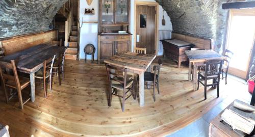 a kitchen with wooden floors and wooden tables and chairs at B & B La Guiette in Casteldelfino