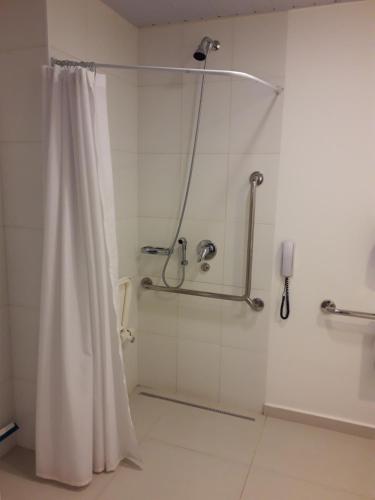 a shower with a shower curtain in a bathroom at ibis budget Osasco in Osasco