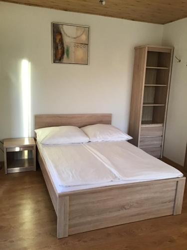 a bedroom with a bed with white sheets at Agroturystyka Krajno - Zagórze in Krajno Pierwsze