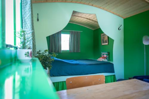 a bedroom with green walls and a bed with a table at Shanti B&B in Deventer