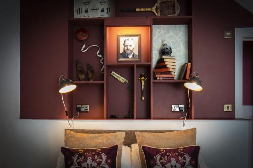 a room with red walls with shelves and pillows at The Bath Hotel in Lynmouth