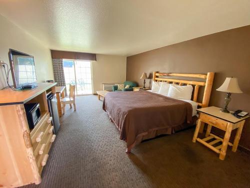 ein Hotelzimmer mit einem Bett und einem TV in der Unterkunft Sisters Inn & Suites in Sisters