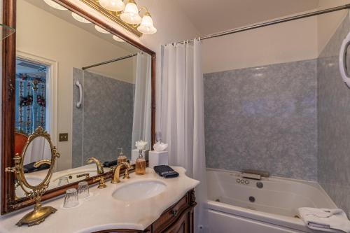 a bathroom with a sink and a tub and a mirror at Apples Bed and Breakfast Inn in Big Bear Lake