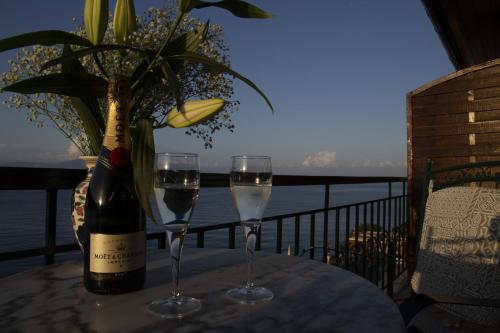 two glasses of wine on a table with a bottle of wine at Margina Residence Hotel in Gaios
