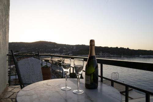 a bottle of wine sitting on a table with two glasses at Margina Residence Hotel in Gaios