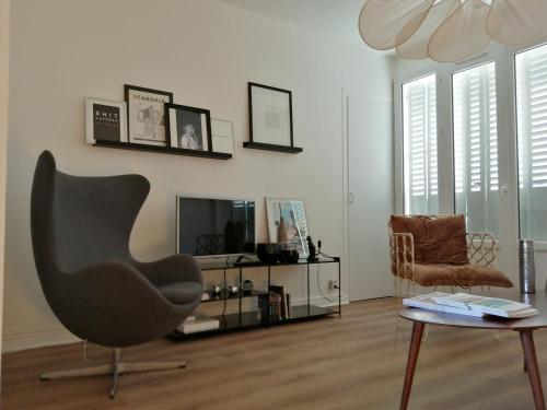 un soggiorno con sedia e TV di Appartement à 300 m du lac et des commerces ad Annecy