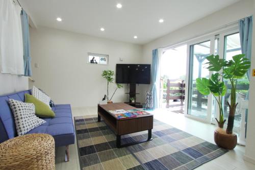 a living room with a blue couch and a table at Comfort Villa V "limited to one group" in Inbu