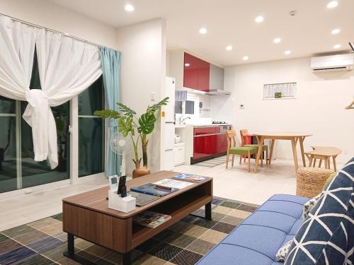a living room with a blue couch and a table at Comfort Villa V "limited to one group" in Inbu