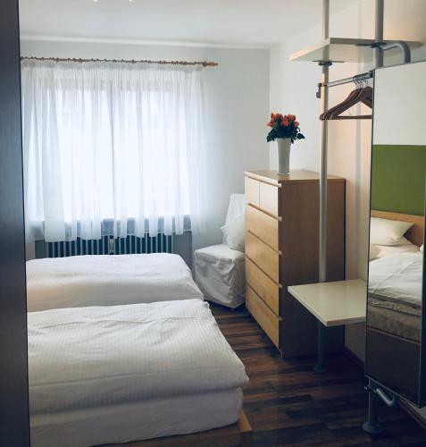a bedroom with two beds and a dresser and a window at Ferienwohnungen Hecker in Bad Gögging