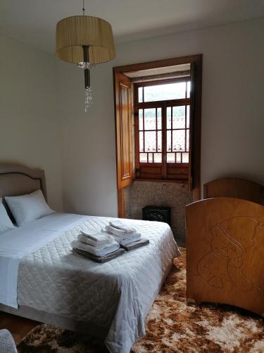 a bedroom with a bed with towels on it at Casa Real in Barcelos
