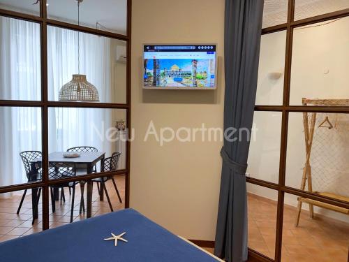 ナポリにあるCaprese Experience - Light Blu Apt - Danteの壁にテレビとテーブルが備わる客室です。