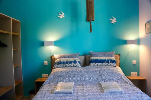 a bedroom with a bed with a blue wall at Casa Anthos in Chania Town