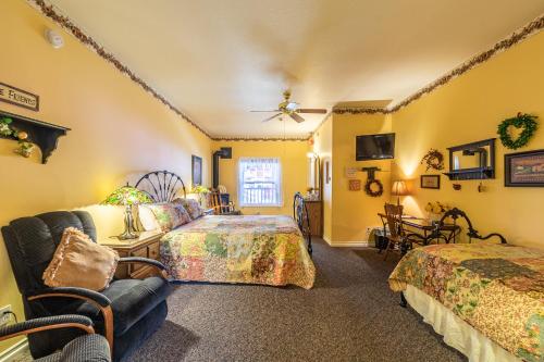 a bedroom with two beds and a couch and a chair at Apples Bed and Breakfast Inn in Big Bear Lake