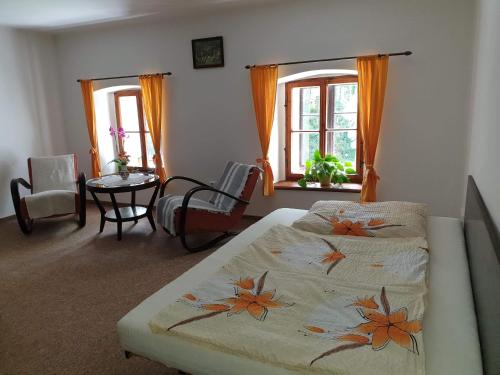 1 dormitorio con cama, mesa y ventanas en Usedlost Pod lipou, en Malá Morava