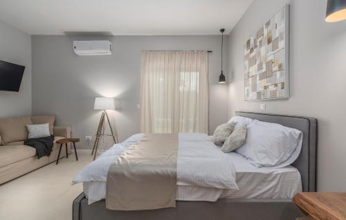 a white bedroom with a bed and a couch at Martinela Villas Istria - Villa Vito in Barban