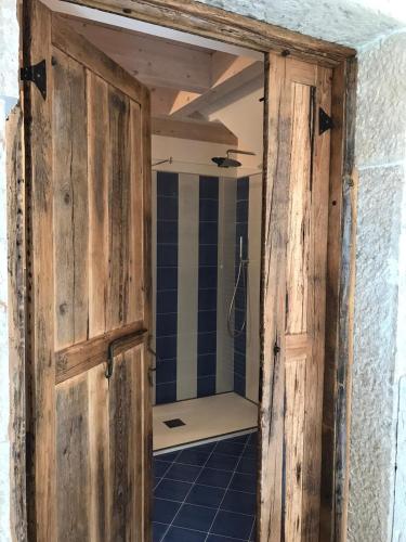 a bathroom with a wooden door and a shower at CORTE CAIAR Bed&Breakfast in Caprino Veronese